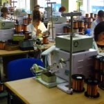 Работник на производственной линии катушек